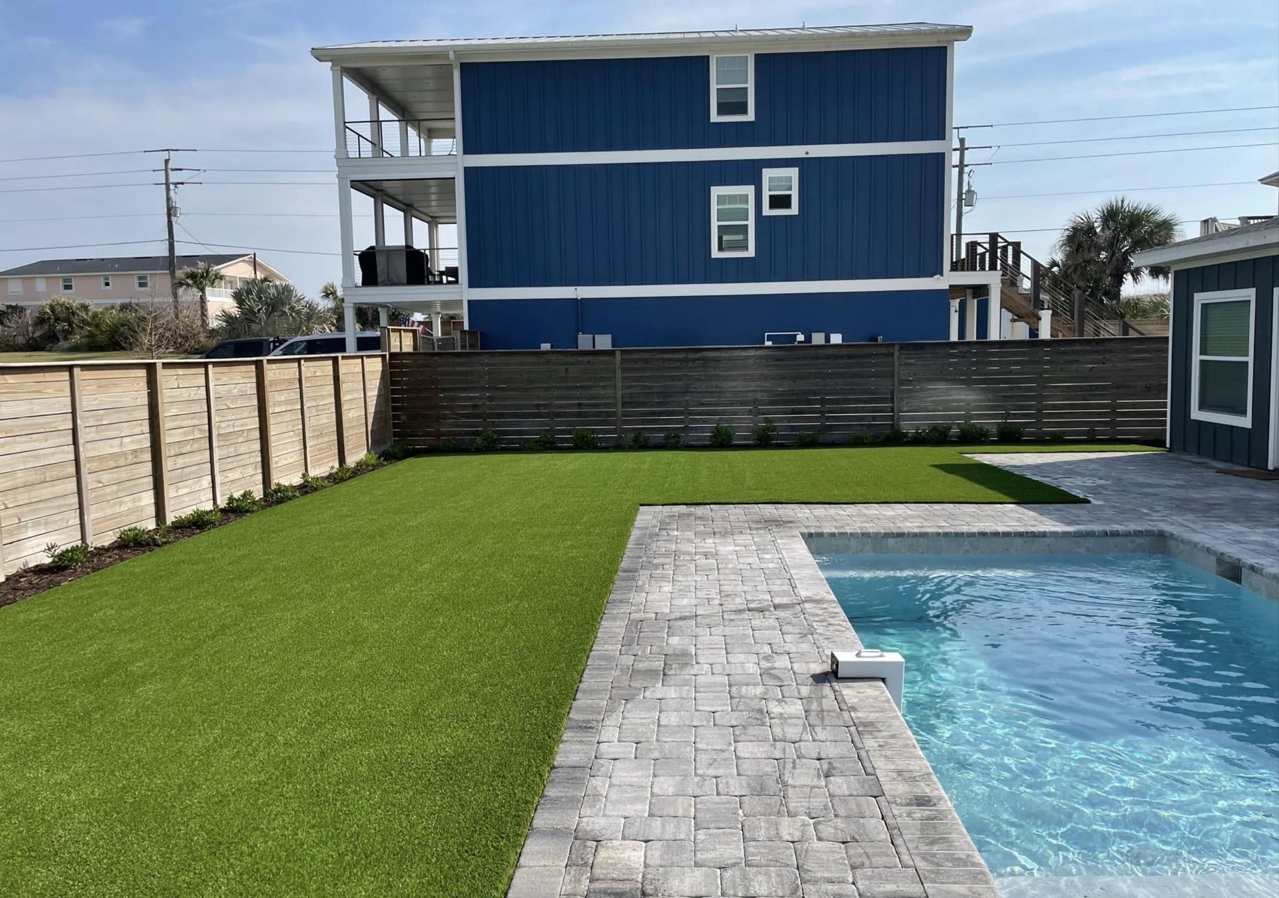 Backyard putting green with paver surround installed by Baker Greens in St. Augustine