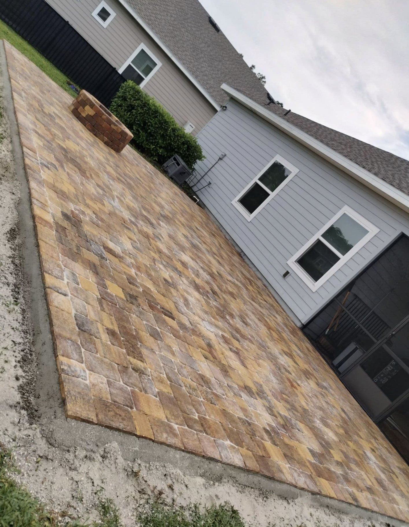 Multi-tone paver patio mid-install on sand-set base